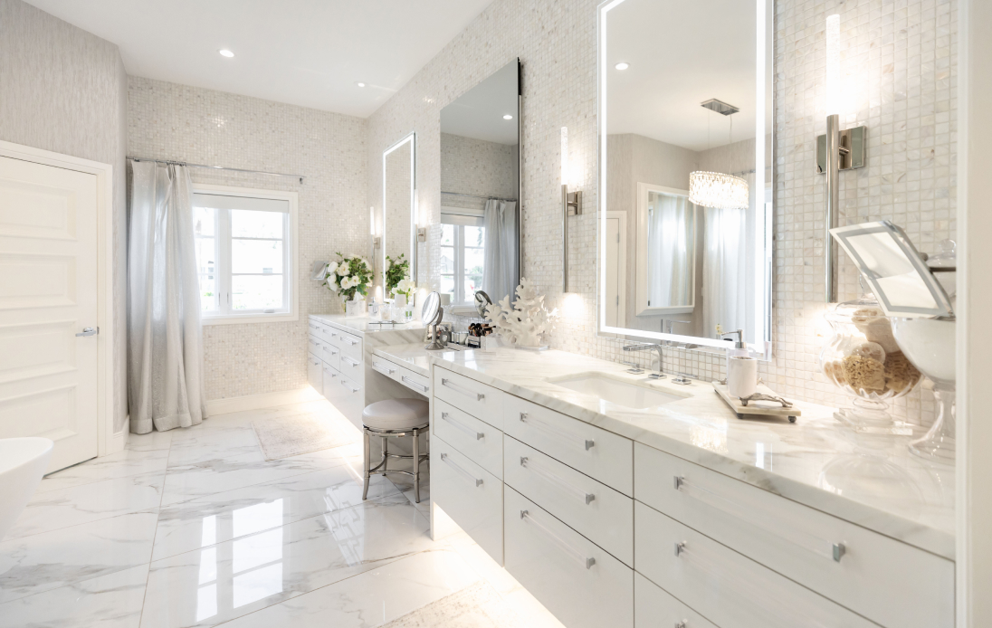 Luxury white master bathroom with dual vanity, lighted mirrors, white marble countertops, and patterned tile walls.