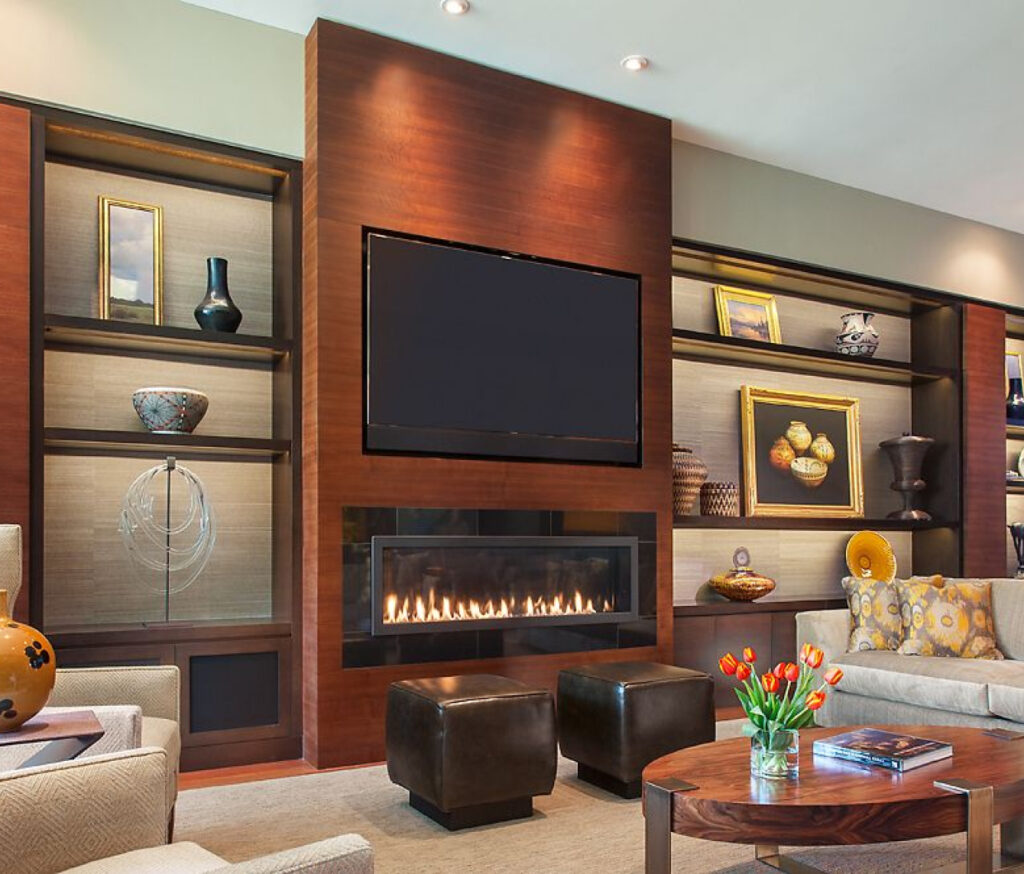 Luxurious modern living room with custom dark wood built-ins, television, and linear fireplace, showcasing Woodcrest Design's craftsmanship.