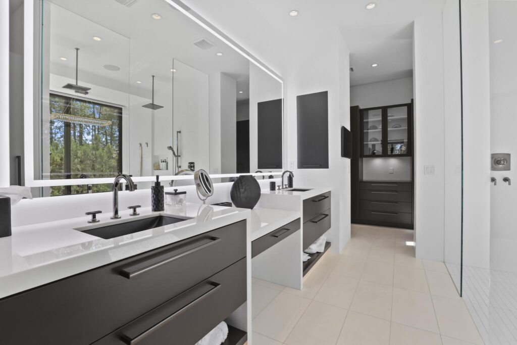 Luxurious modern master bathroom with double vanity, dark brown cabinetry, white countertops, and sleek black fixtures.