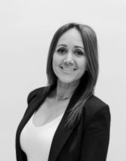 Smiling woman in black blazer, representing Woodcrest Design's integrated design-build team.